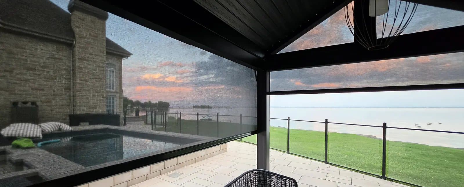 Pavillon de piscine fermé par des toiles solaires extérieures à glissières, au coucher du soleil, Vaudreuil-Soulanges