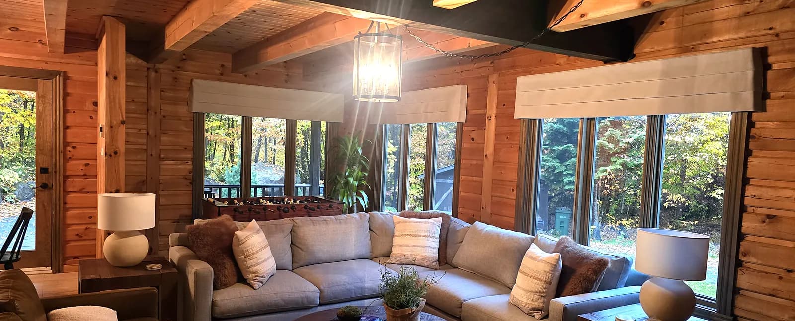Stores romains au-dessus des fenêtres d'un chalet en bois rond dans les Laurentides