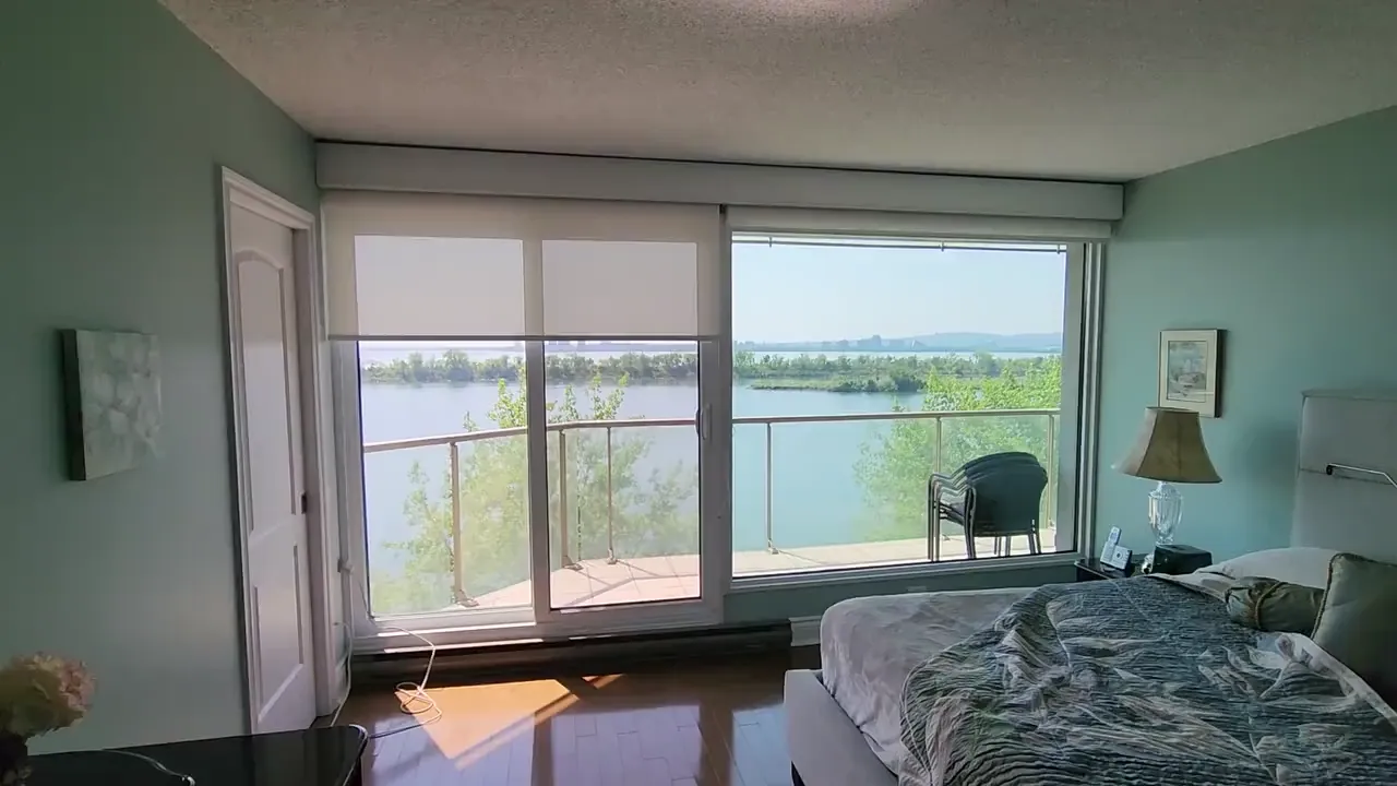 Toiles doubles motorisées dans une chambre de penthouse avec vue sur l'eau, Brossard